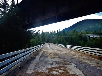 A person in a hard hat stands on an old bridge.